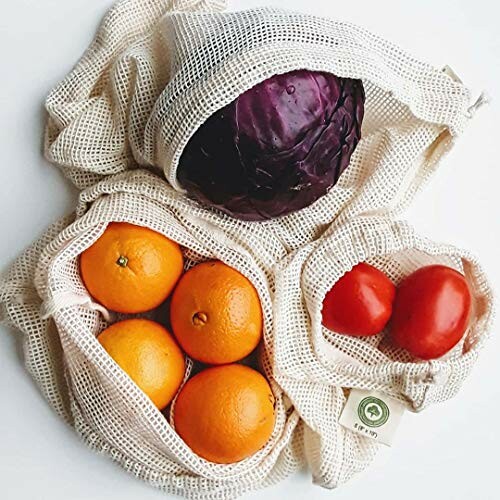 Mesh bags containing a purple cabbage, oranges, and tomatoes.