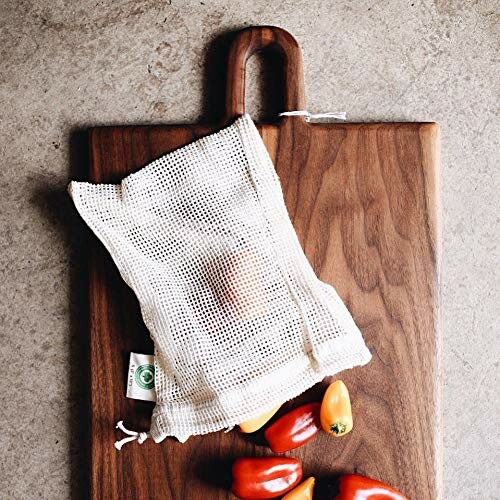 Wooden cutting board with mesh bag and peppers